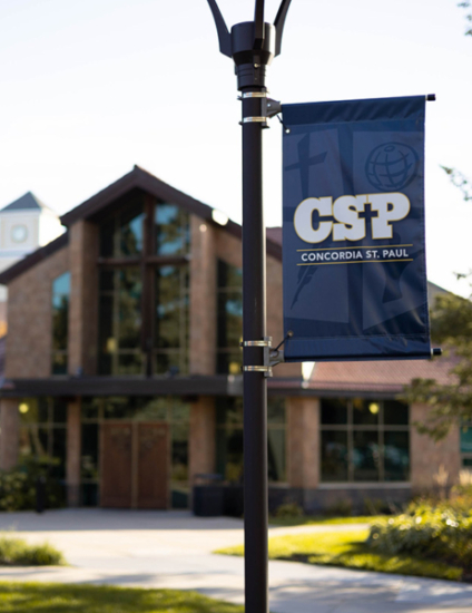 Brown chapel building behind a blue and white CSP banner.