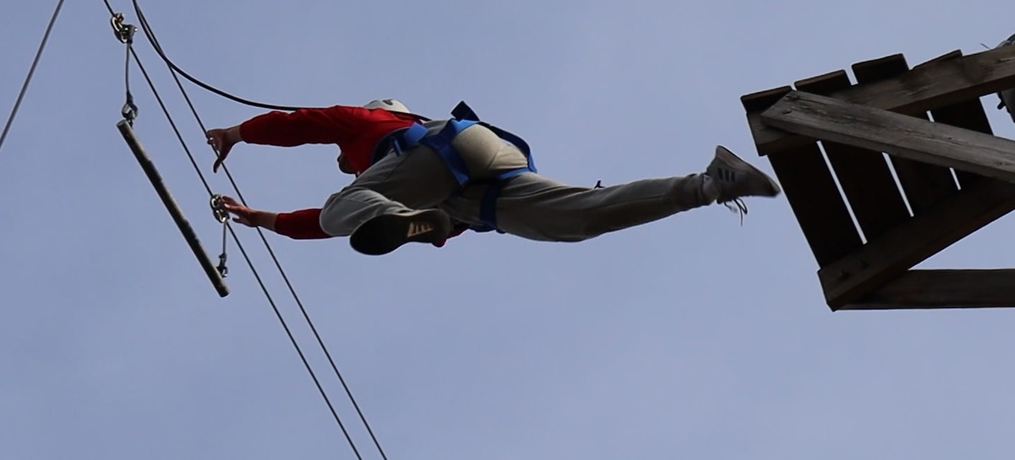 Student Jumping in a ropes course