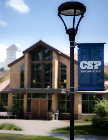 Brown chapel building behind a blue and white CSP banner.